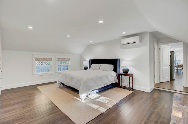 bedroom with dark hardwood / wood-style flooring, stainless steel refrigerator, a wall unit AC, and vaulted ceiling