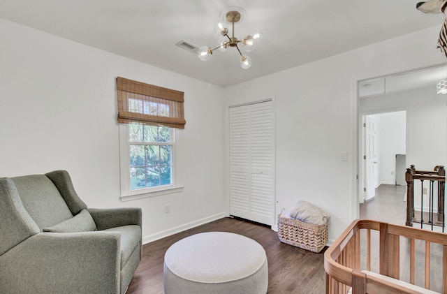 sitting room featuring a chandelier and dark wood-type flooring