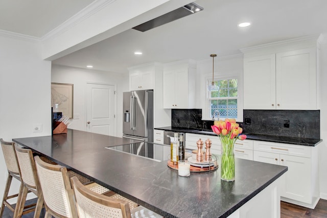 kitchen with tasteful backsplash, white cabinets, pendant lighting, and appliances with stainless steel finishes