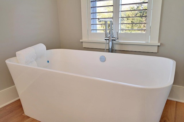 room details featuring hardwood / wood-style floors and a tub