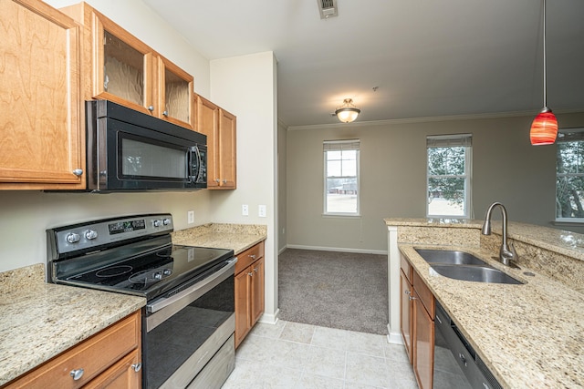 kitchen featuring visible vents, hanging light fixtures, light stone countertops, black appliances, and a sink