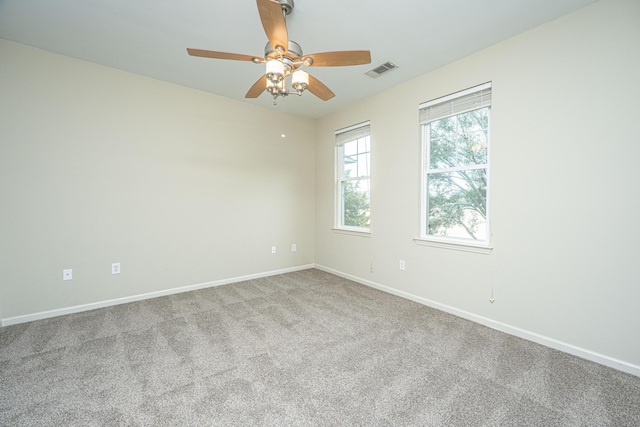 empty room with visible vents, ceiling fan, light carpet, and baseboards