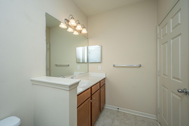 bathroom featuring toilet, vanity, baseboards, and tile patterned floors