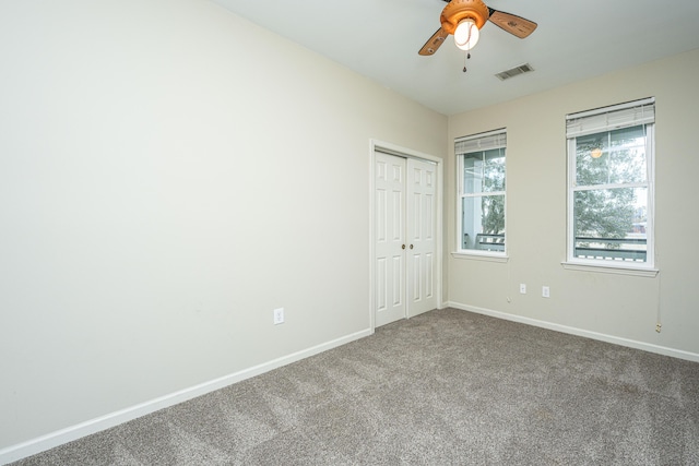 unfurnished bedroom with baseboards, visible vents, a ceiling fan, carpet floors, and a closet