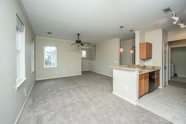 kitchen featuring open floor plan, brown cabinetry, light carpet, and decorative light fixtures