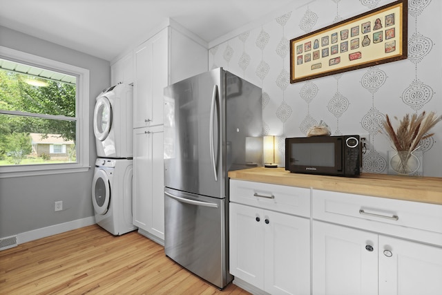 2605 Mona Ave, Charleston, SC 29414 - kitchen featuring estacked washer and dryer, black microwave, freestanding refrigerator, light wood finished floors, and baseboards