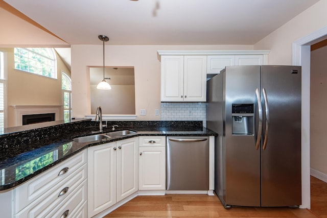 kitchen featuring dark stone countertops, sink, white cabinets, and appliances with stainless steel finishes