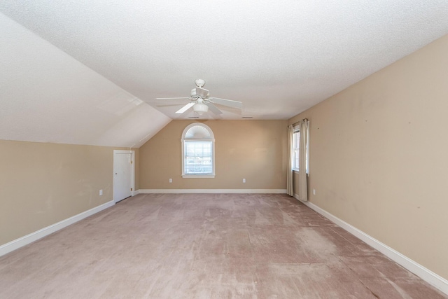 additional living space featuring ceiling fan, lofted ceiling, and a textured ceiling