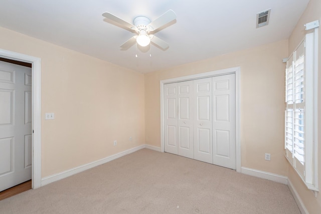 unfurnished bedroom with light carpet, ceiling fan, and a closet