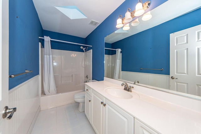 full bathroom with shower / tub combo, a skylight, vanity, tile patterned floors, and toilet