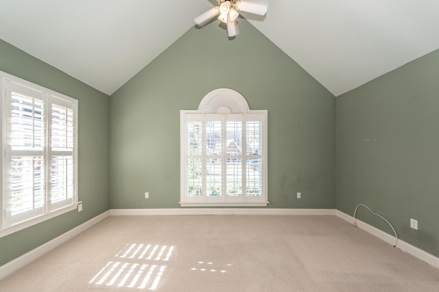 carpeted spare room featuring high vaulted ceiling and ceiling fan