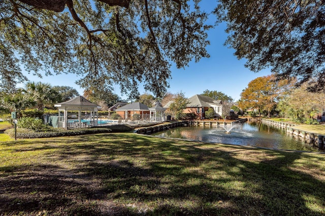 view of dock featuring a gazebo, a lawn, and a water view