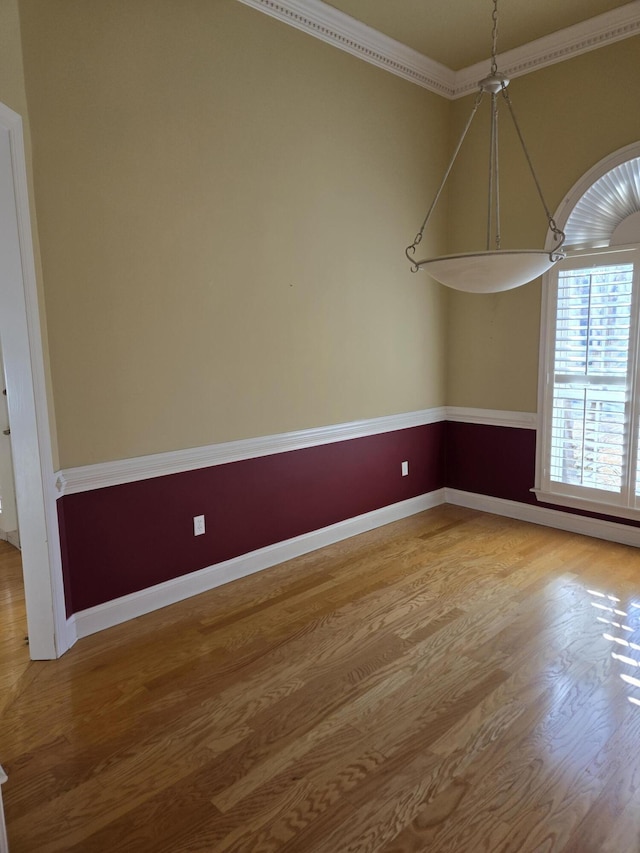 unfurnished room featuring ornamental molding and hardwood / wood-style floors