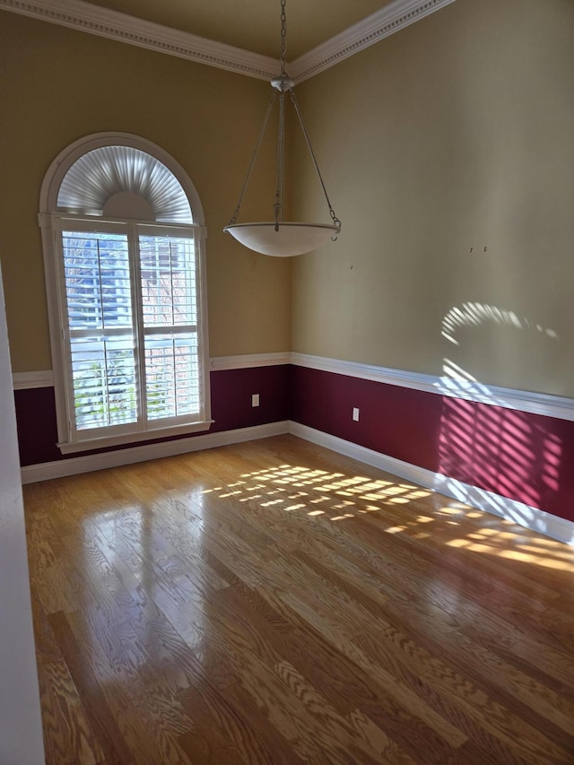 unfurnished dining area with ornamental molding and wood-type flooring