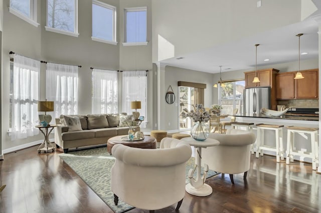 living area featuring dark wood-type flooring, recessed lighting, a high ceiling, and baseboards