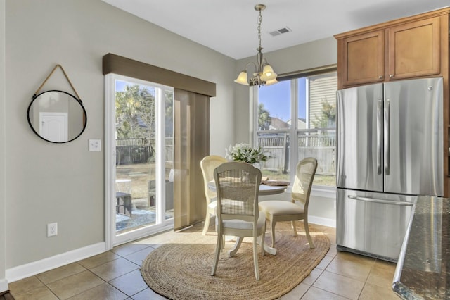 dining room featuring light tile patterned floors, baseboards, and a notable chandelier