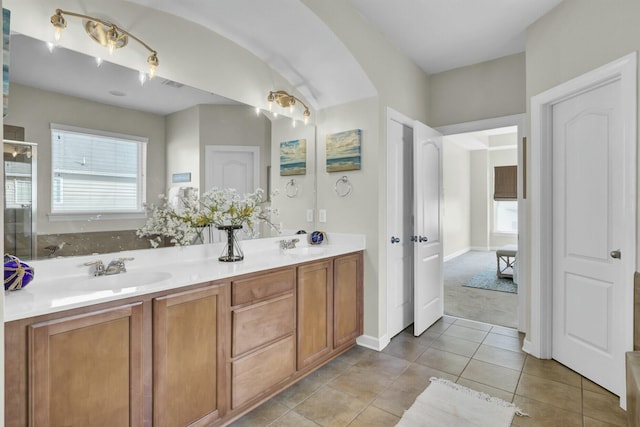 full bath with tile patterned flooring, an enclosed shower, a sink, and double vanity