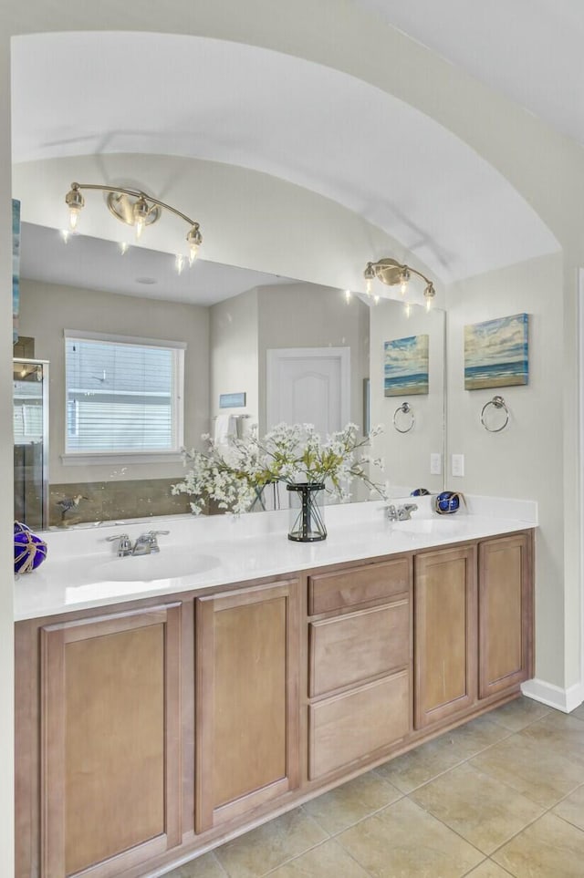 bathroom featuring double vanity, a sink, and tile patterned floors