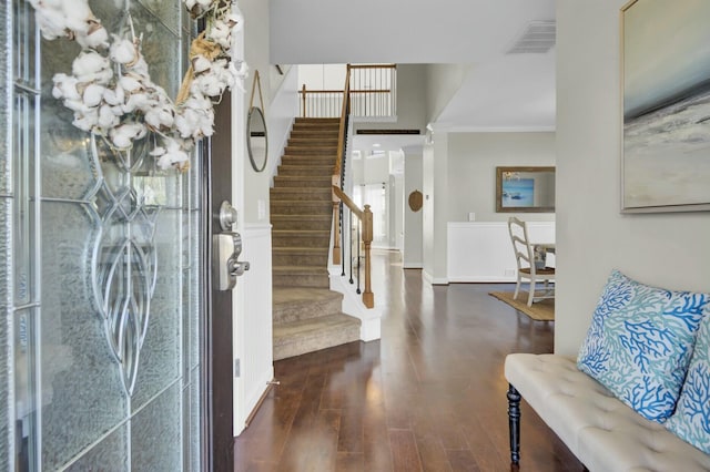 foyer with visible vents, crown molding, stairway, and wood finished floors