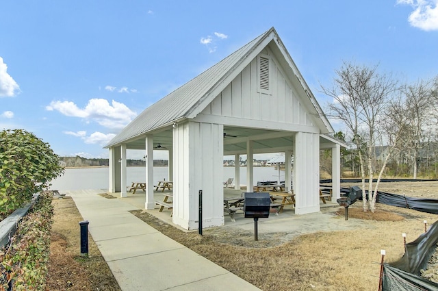 surrounding community with a water view and a patio