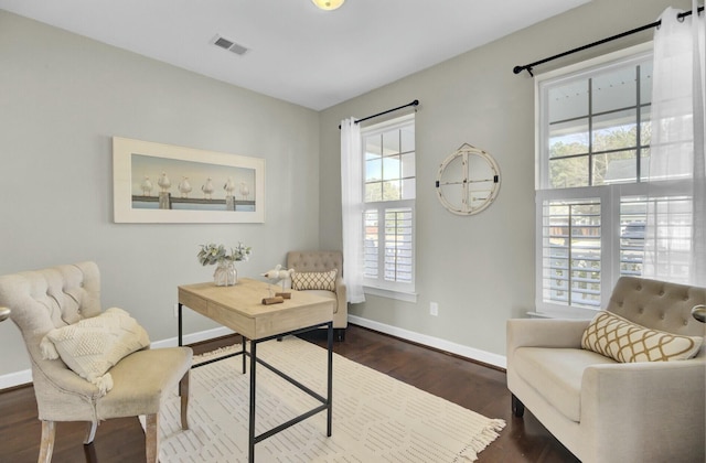 office space with dark wood-type flooring, visible vents, and baseboards