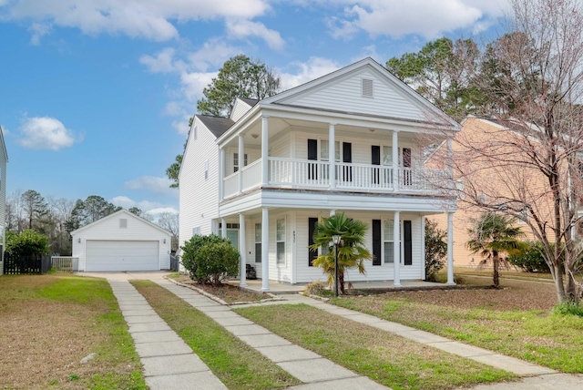 greek revival house featuring an outbuilding, a porch, a front yard, and a garage