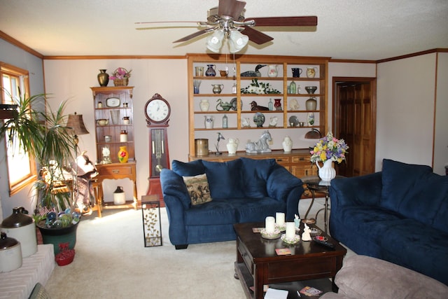 living room featuring a ceiling fan, ornamental molding, a textured ceiling, and light colored carpet