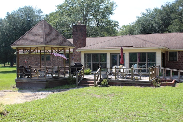 back of property with a shingled roof, a chimney, a gazebo, a yard, and brick siding