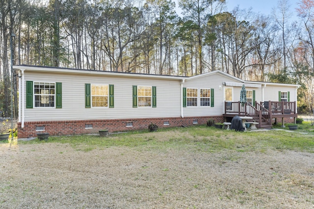 view of front of property featuring a front yard, a deck, and crawl space