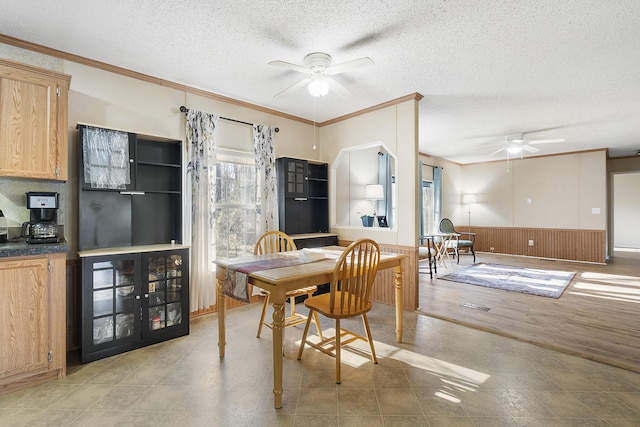dining room featuring a textured ceiling, a ceiling fan, and ornamental molding