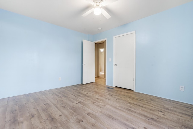 unfurnished room with visible vents, a ceiling fan, and light wood finished floors