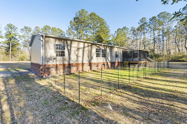 view of front of property with a front lawn, fence, and a sunroom
