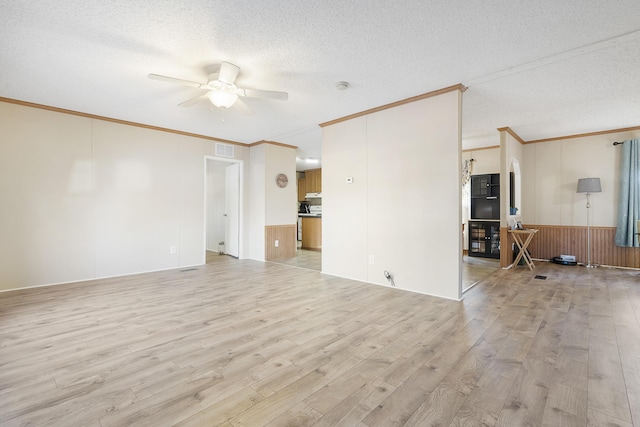 unfurnished living room featuring ornamental molding, a textured ceiling, a ceiling fan, visible vents, and light wood finished floors