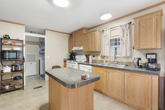 kitchen featuring under cabinet range hood, a sink, white appliances, and dark countertops