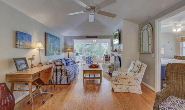 living room featuring ceiling fan, light hardwood / wood-style floors, and lofted ceiling