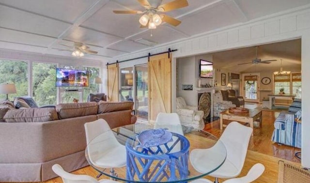 dining area with hardwood / wood-style floors, a barn door, and coffered ceiling