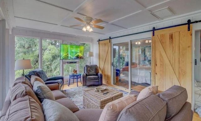 interior space with a barn door, ceiling fan, and coffered ceiling