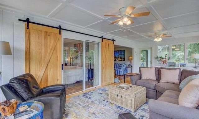 living room with ceiling fan, a barn door, and coffered ceiling