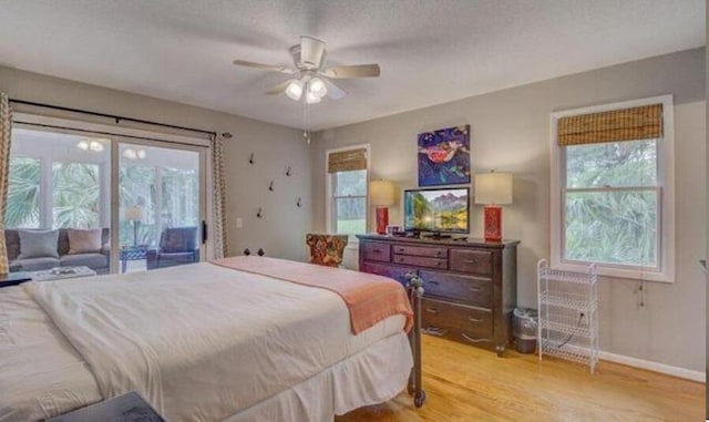 bedroom featuring access to exterior, ceiling fan, light hardwood / wood-style flooring, and a textured ceiling