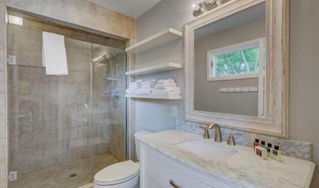 bathroom with vanity, an enclosed shower, and toilet