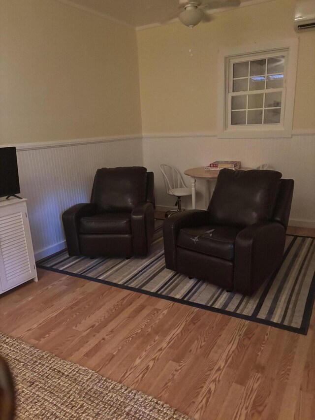 living room featuring ceiling fan, wood-type flooring, and a wall mounted AC