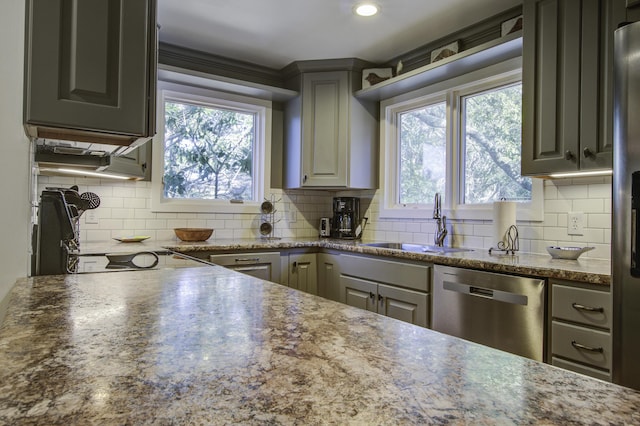 kitchen featuring stainless steel dishwasher, decorative backsplash, gray cabinetry, and sink