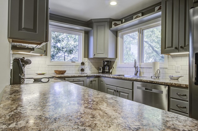 kitchen with gray cabinetry, dishwasher, backsplash, and sink