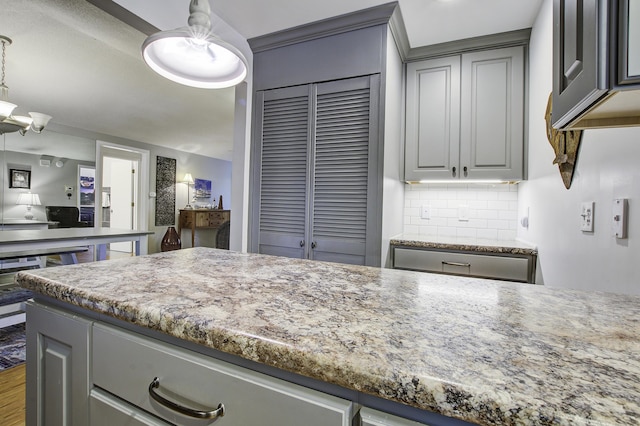 kitchen with pendant lighting, gray cabinets, and backsplash