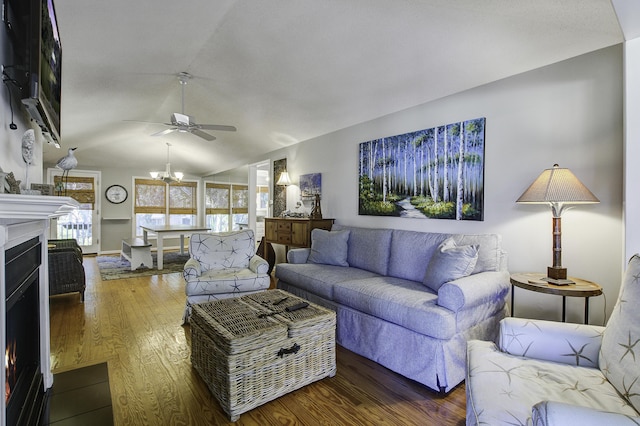 living room with hardwood / wood-style floors, ceiling fan with notable chandelier, and lofted ceiling