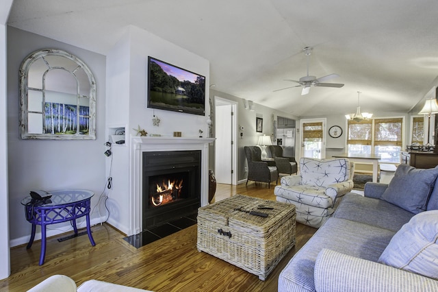 living room with dark hardwood / wood-style flooring, ceiling fan with notable chandelier, and lofted ceiling