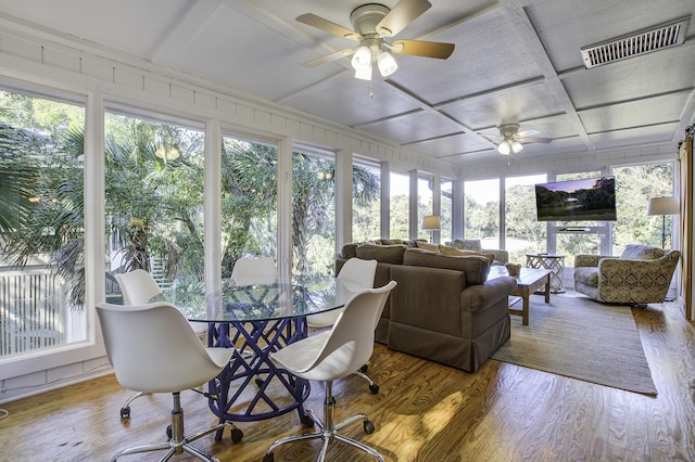 sunroom / solarium featuring ceiling fan, a healthy amount of sunlight, and coffered ceiling