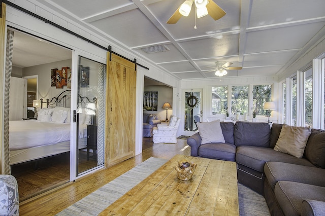 sunroom / solarium featuring ceiling fan, a barn door, and coffered ceiling