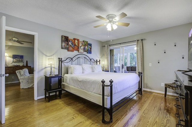 bedroom featuring ceiling fan, wood-type flooring, and a textured ceiling