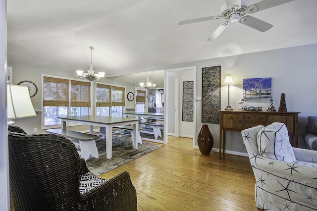 living room featuring hardwood / wood-style floors, ceiling fan with notable chandelier, and lofted ceiling